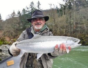 An angler holding a  winter steelhead caught at applegate river.