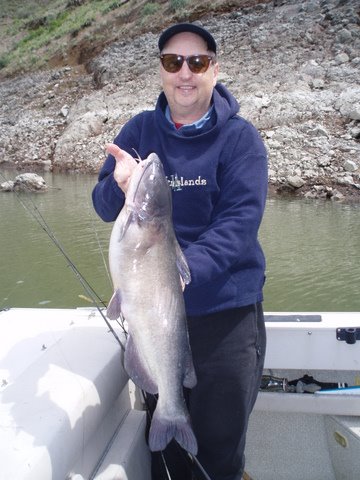 An angler holding a big channel catfish caught at Brownlee Reservoir.