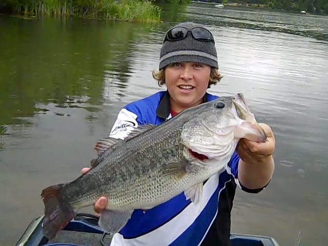 An angler holding a trophy-sized largemouth bass.