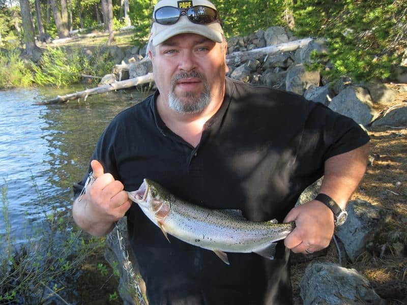 An angler holding a crane prairie trout.