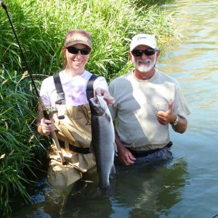 Two anglers showcasing a summer steelhead caught at lower deschutes river.