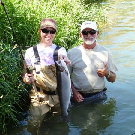 Two anglers showcasing a summer steelhead caught at lower deschutes river.