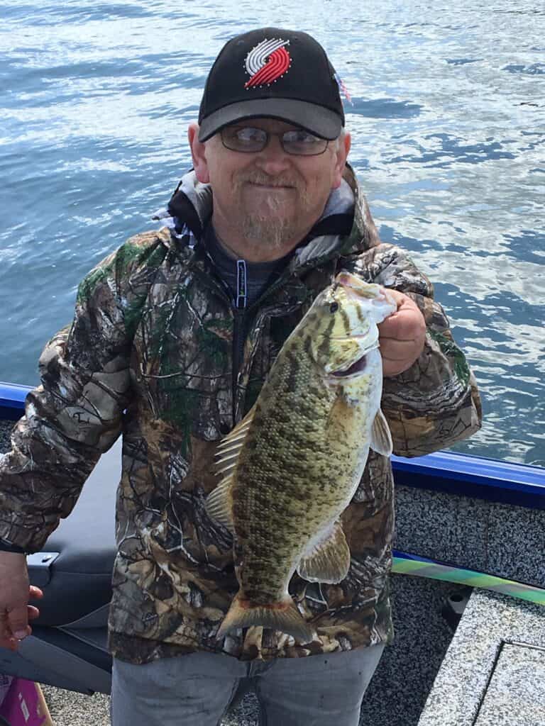  An angler holding a smallmouth bass caught in Hagg Lake.