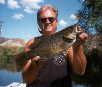 An angler holding a smallmouth bass caught at john day river.
