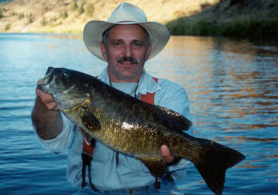 An angler holding a smallmouth bass caught at john day river.