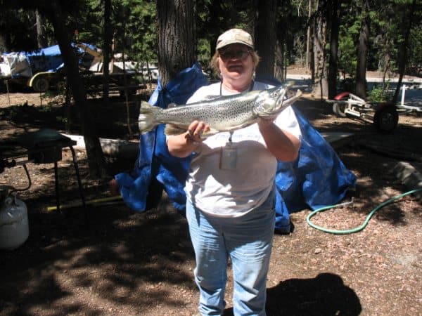 An angler holding a large brown trout caught at miller lake in oregon.