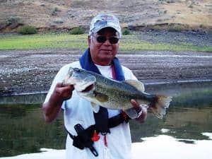 An angler holding a largemouth bass caught at prineville reservoir.