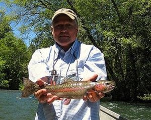 An angler holding a fish caught at the middle fork of willamette river.