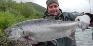 An angler holding a giant nestucca river steelhead.