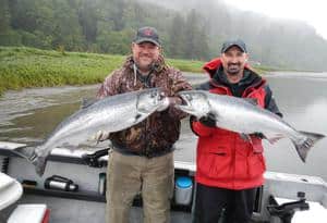 Two anglers showcasing their caught fish.