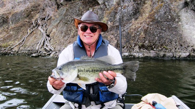 An angler holding a largemouth bass caught at prineville reservoir, oregon.