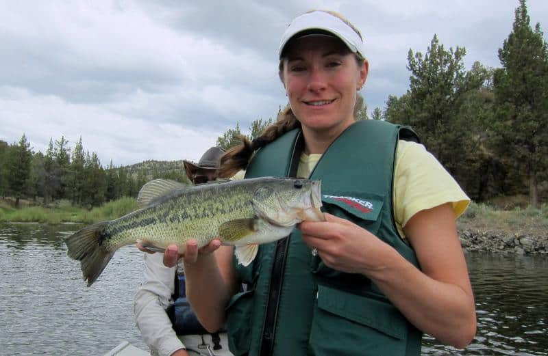 A woman holding prineville largemouth bass.