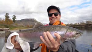 An angler holding a winter steelhead caught at rogue river.