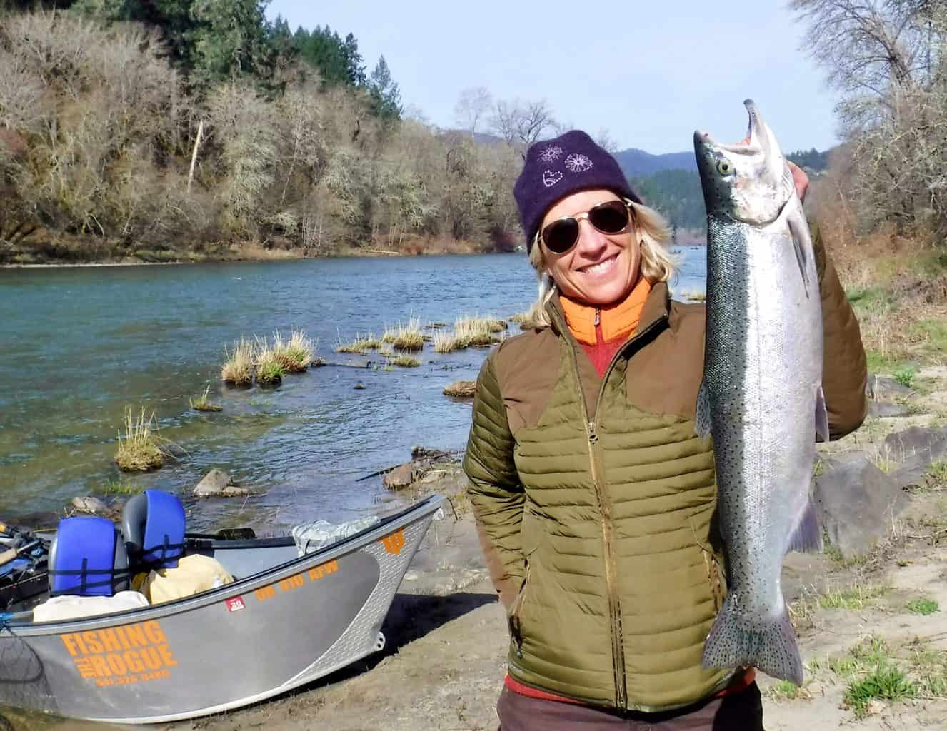 Angler holding a nice steelhead caught while fishing on the rogue river.