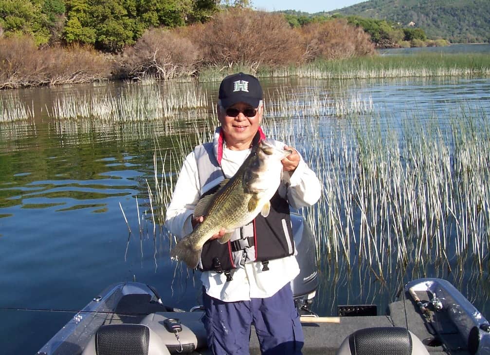 An angler holding a largemouth bass.