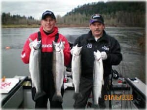 Two anglers showcasing their caught steelhead.