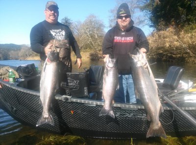 Two anglers showcase their caught chinook salmon.