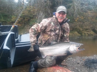 An angler holding a fall chinook caught at siletz river.