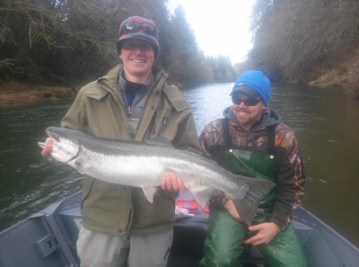 Anglers holding a winter steelhead caught at siletz river.