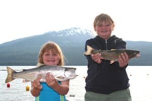 Two young anglers hold up large trout they caught at diamond lake in oregon.