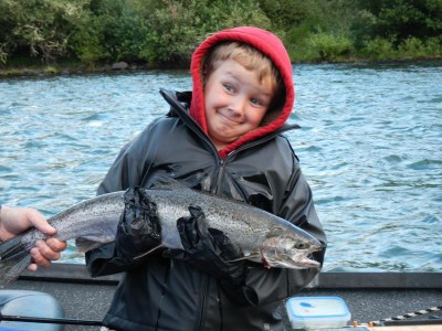 A grinning kid holding a big steelhead.