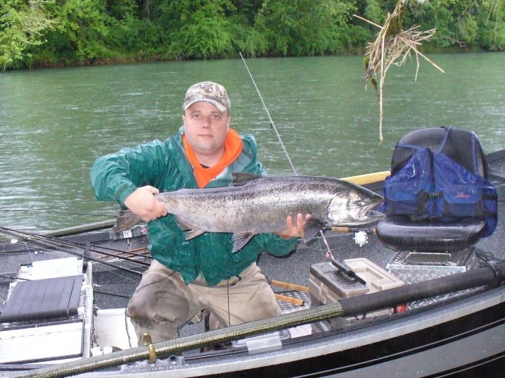An angler holding a spring chinook salmon caught at south santiam river.