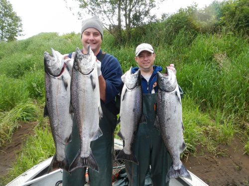 Two anglers showcasing their caught trask river chinook salmon.