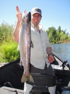 An angler holding a summer steelhead caught at upper rogue river.