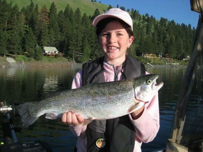 Girl holds up a large rainbow trout caught at wallowa lake.