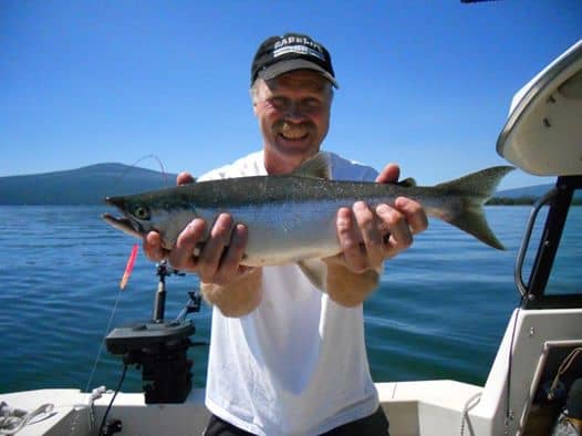 An angler holding a large wickiup reservoir kokanee salmon.