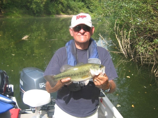 An angler holding a largemouth bass caught on the lower Yamhill River in Yamhill County.