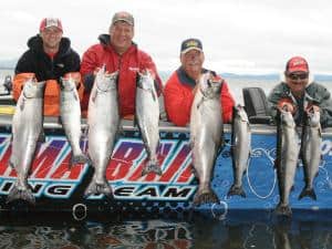 A group of fishermen holding their salmon caught at Buoy 10.