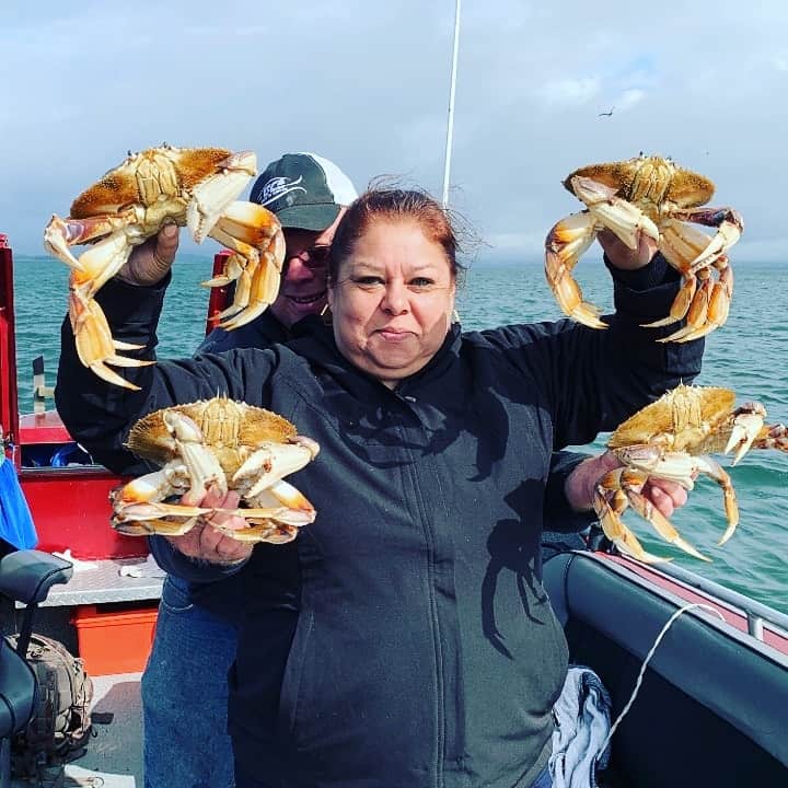 A couple holding up dungeness crabs caught in tillamook bay in oregon.