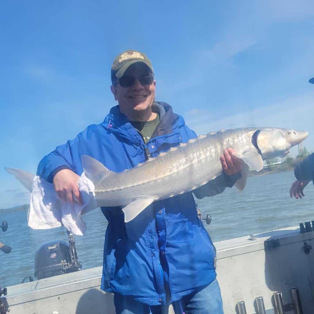 Eric Apalategui, owner and publisher of Best Fishing in America, holds a white sturgeon caught on the Willamette River.