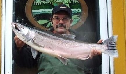 An angler holding a coho salmon caught at sandy river.