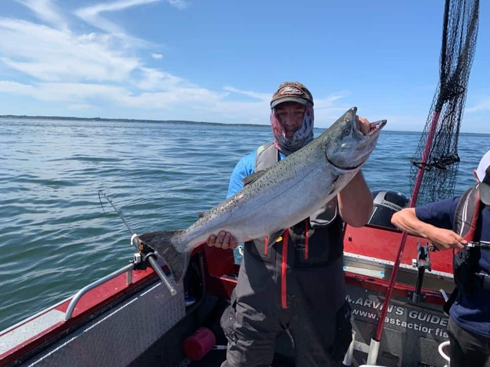 An angler holding a salmon caught at tillamook bay.