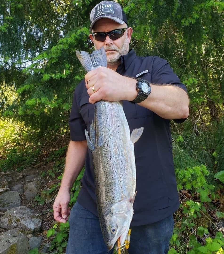 An angler holds a giant trout by the tail after landing it while fishing at Cottage Grove Reservoir in Lane County, Oregon.