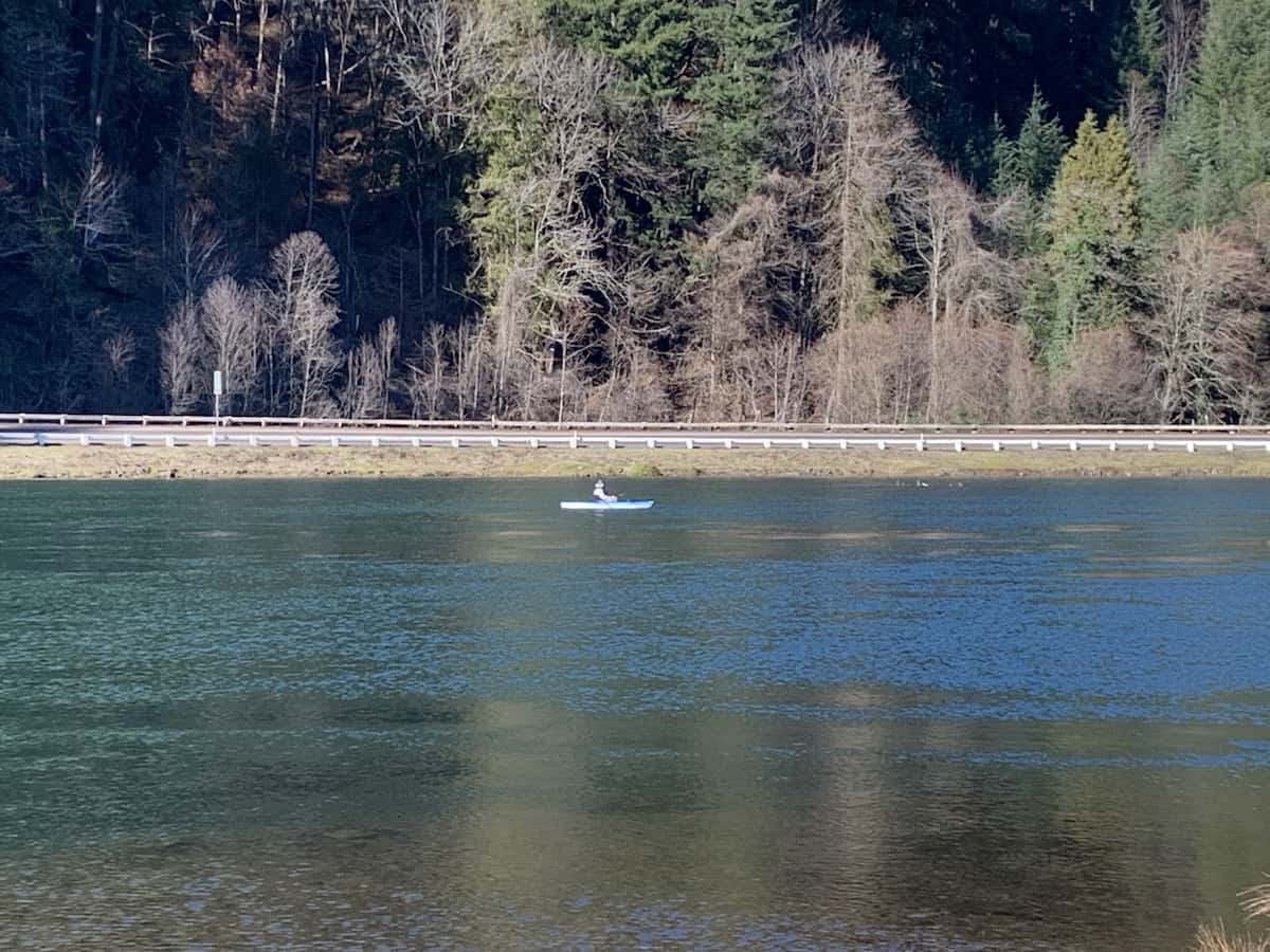 An angler in a kayak fishes for trout at Leaburg Lake during the winter.