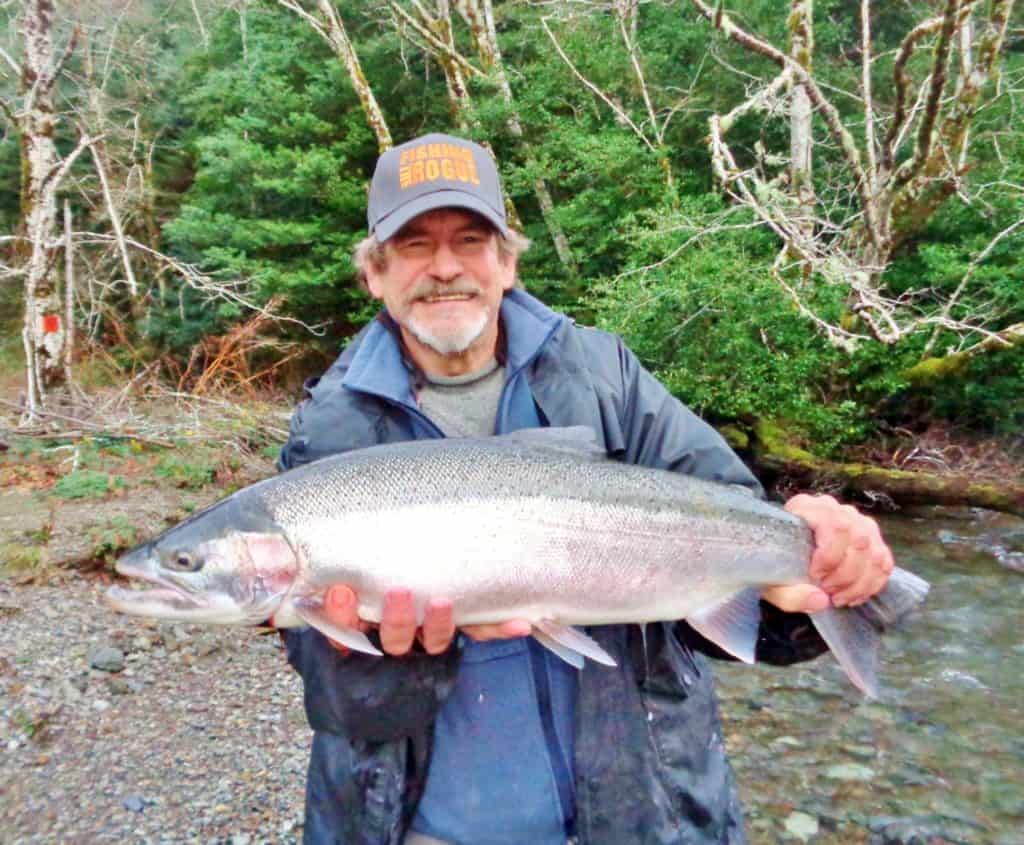 An angler holding a steelhead caught at elk river, oregon.