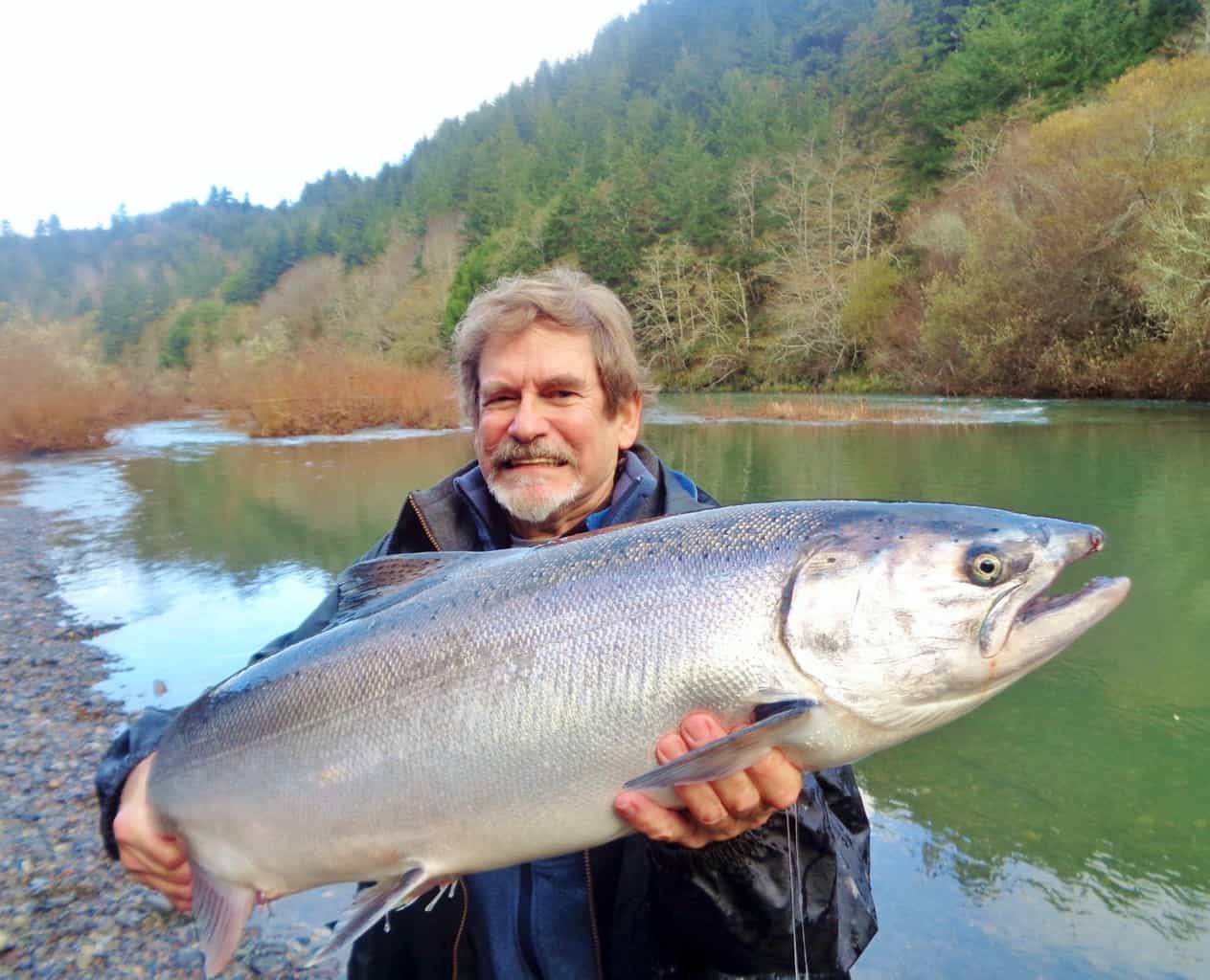 An angler holding a salmon caught at elk river.