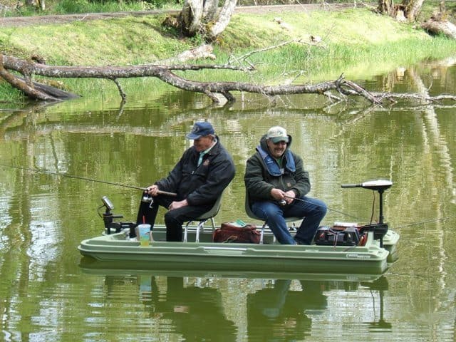 Two anglers fish from a small boat at vernonia lake.