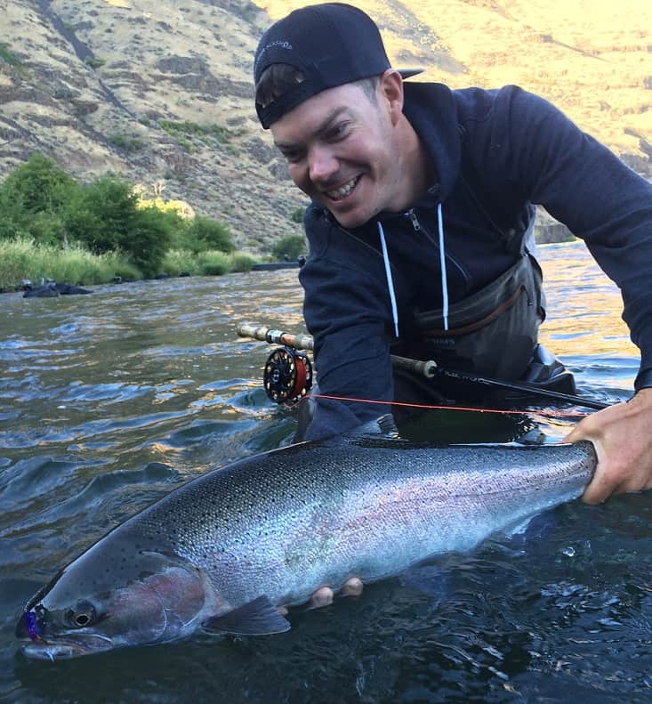 An angler holding a deschutes river steelhead.