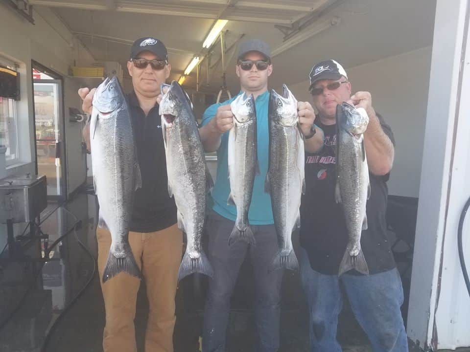 Anglers showcasing caught salmon in the columbia river.