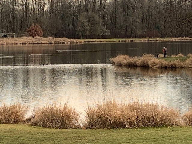 A scenic photo of recreation lake with two young anglers in the background.