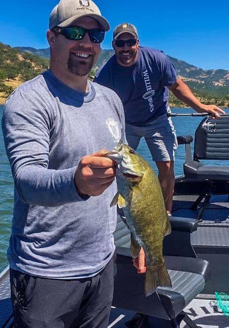 An angler holding a smallmouth bass caught at lost creek lake in southern oregon.