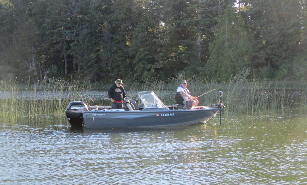 A couple of anglers fish from a boat at Siltcoos Lake.