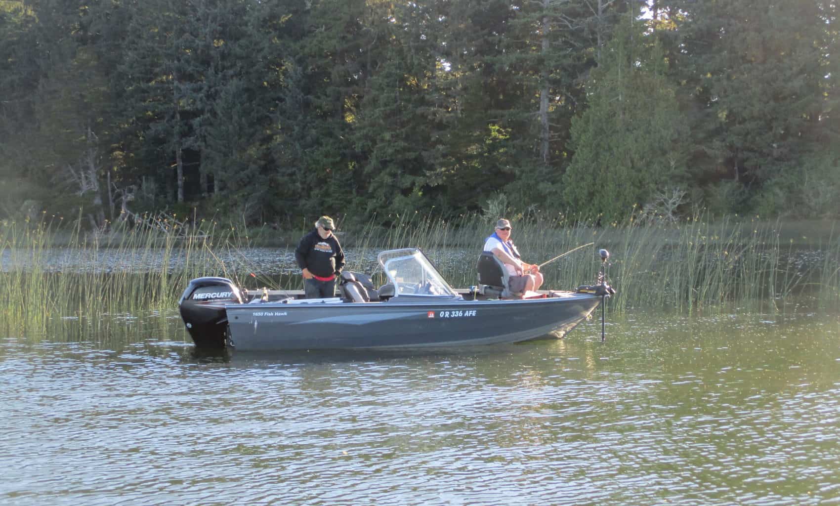 Two anglers on a boat on siltcoos lake.