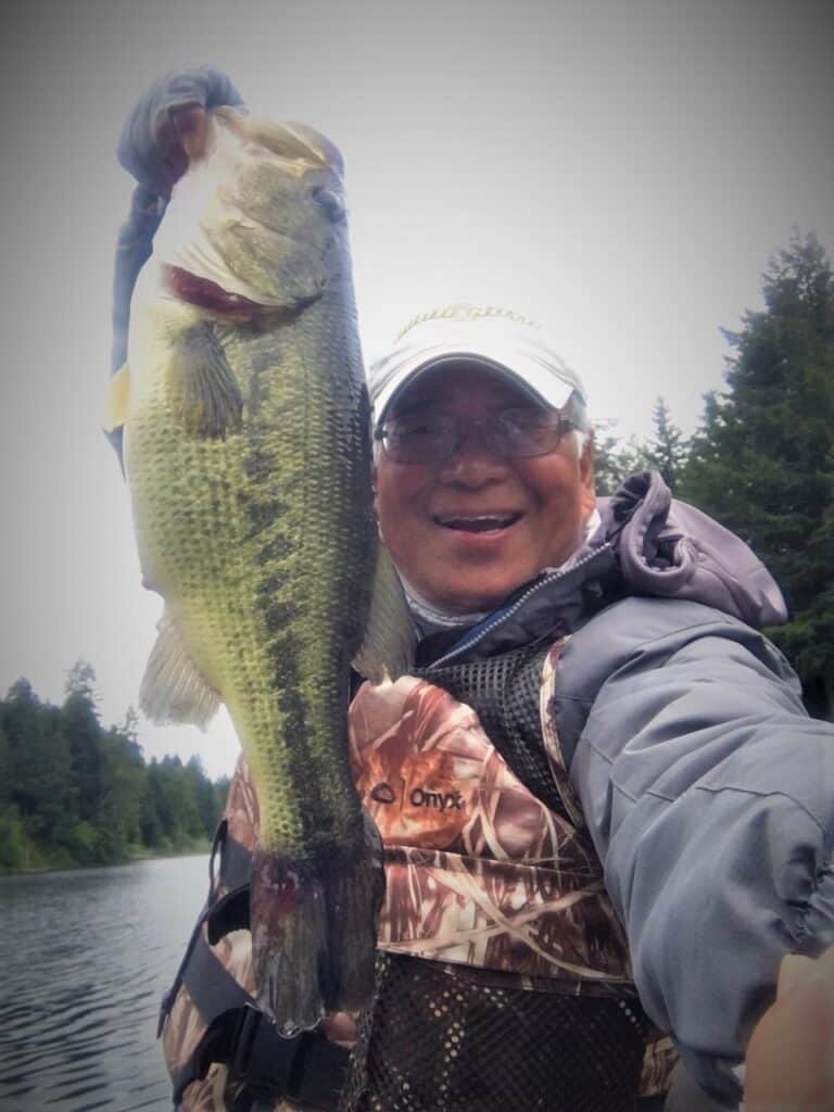 Angler holding a largemouth bass caught at tenmile lakes.