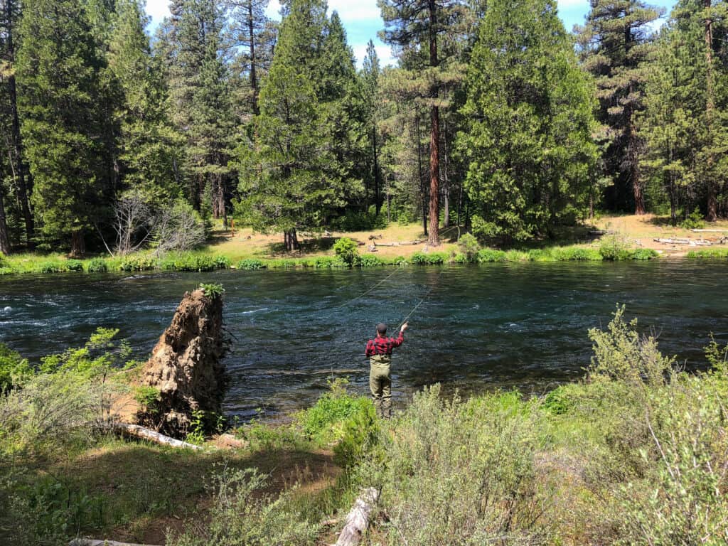 An angler fly fishing in the metolius river.