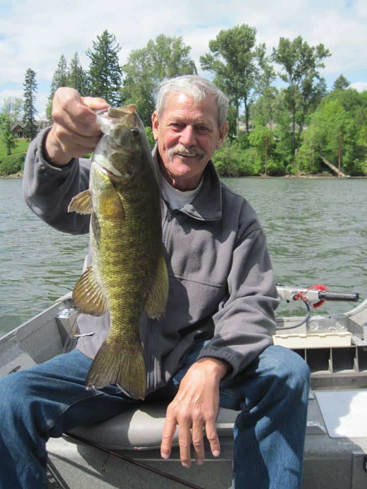 An angler holds up a nice smallmouth bass caught on a ned rig.